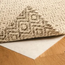 auf einem Parkettboden liegt ein hochgeklappter Teppich, darunter ist die Teppichunterlage sichtbar - auf einem Parkettboden liegt ein hochgeklappter Teppich, darunter ist die Teppichunterlage sichtbar
